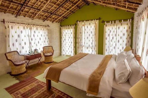 a bedroom with a bed and a green wall at Camp Lands End in Pushkar