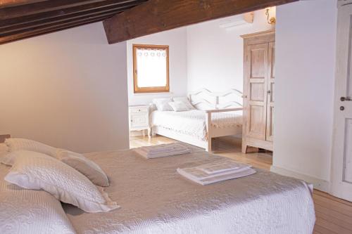 a white bedroom with a bed and a couch at Casa MYCONIS 68Mq a due passi dal Mare di San Vincenzo in San Vincenzo