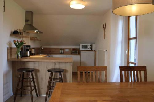 una cucina con tavolo e alcuni sgabelli da bar di Ferienwohnung Teufelsbauer a Rimbach