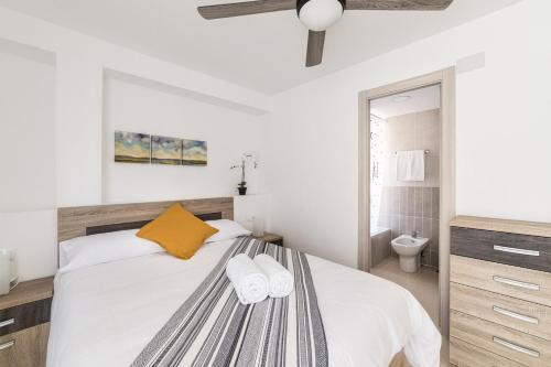 1 dormitorio con 1 cama con 2 toallas en Moonkey - Luminoso Apartamento Girasoles, en Benidorm