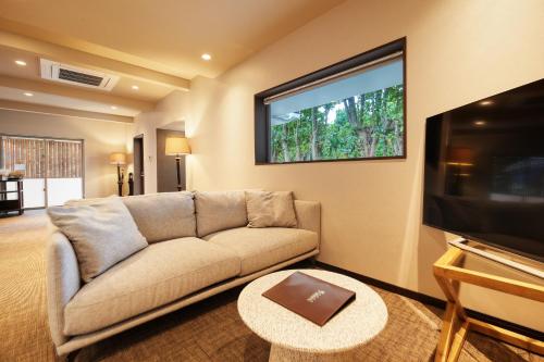 a living room with a couch and a flat screen tv at ADAN RESORT 灯 - Lamp - in Motobu