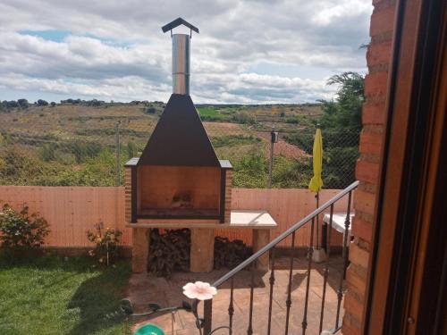 a outdoor fireplace in a yard next to a fence at Vivienda Turística San Martín in Sotés