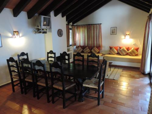 a dining room with a table and chairs and a couch at Pedras Da Rainha in Cabanas de Tavira