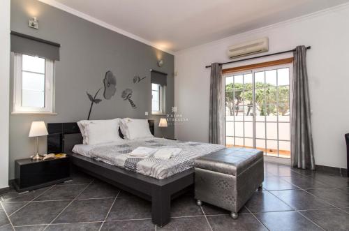 1 dormitorio con 1 cama, 1 silla y 1 ventana en Villa Coelho - By Dalma Portuguesa, en Albufeira
