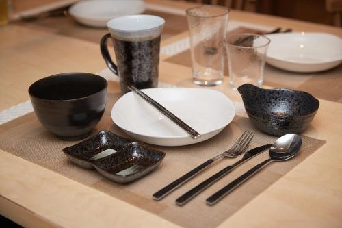 a table with plates and utensils on a table at ADAN RESORT 灯 - Lamp - in Motobu