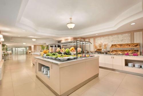 タシュケントにあるウィンダム タシケントの果物や野菜のビュッフェを備えた広いキッチン