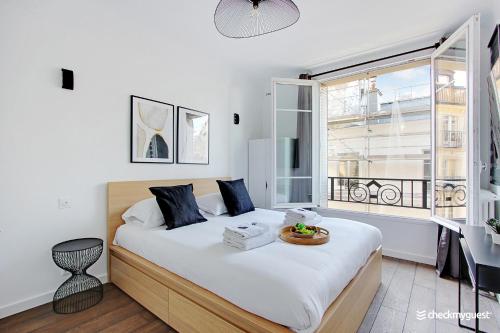 una camera con un grande letto e una finestra di CMG - Place des Vosges a Parigi
