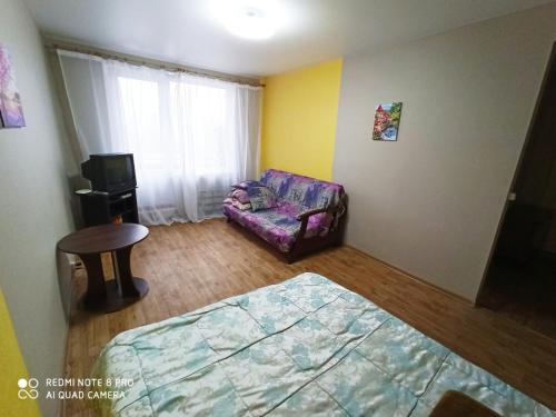 a room with a couch and a chair and a bed at Комфортные аппартаменты возле метро Студенческая in Kharkiv