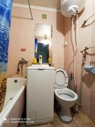 a bathroom with a toilet and a sink and a tub at Комфортные аппартаменты возле метро Студенческая in Kharkiv