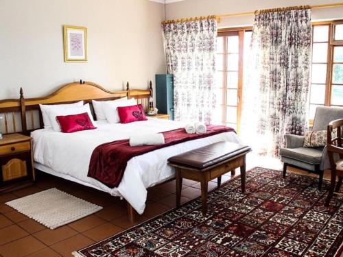 - une chambre avec un grand lit et des oreillers rouges dans l'établissement Mountain Haven Villa, à Wolseley