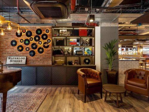 a restaurant with two chairs and a wall with pots and pans at ibis Styles Glasgow Central in Glasgow