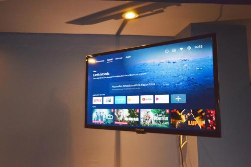a flat screen tv hanging on a wall at Capstay Cosy centre 2 chambres babyfoot & Netflix in Raismes