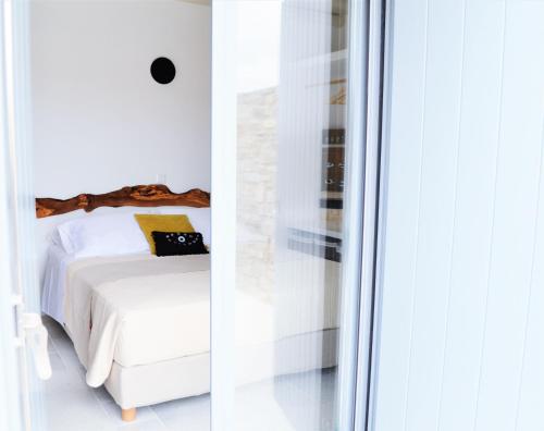 a bedroom with a white bed and a window at Krotiri View Paros in Krotiri