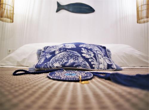a bed with a blue and white pillow and a purse at Krotiri View Paros in Krotiri