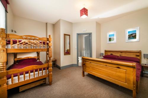 a bedroom with two bunk beds and a hallway at Llangollen Hostel Self-catering in Llangollen