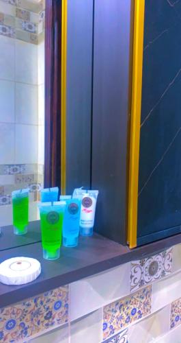 a counter with blue and green cups and a plate at شقق Flower-z in Al-ʿUla