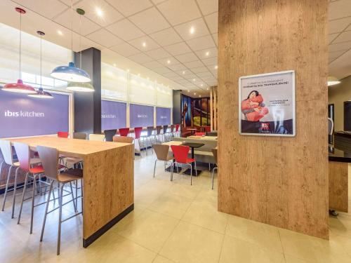 a restaurant with tables and chairs and a picture on a wall at ibis Jacarei in Jacareí