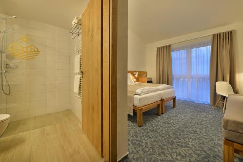 a hotel room with a bed and a bathroom at Wellness Hotel Happy Star in Hnanice