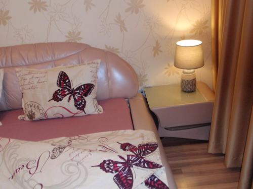 a living room with a couch with butterflies on a pillow at Central Cietokšņa Street Apartment in Daugavpils