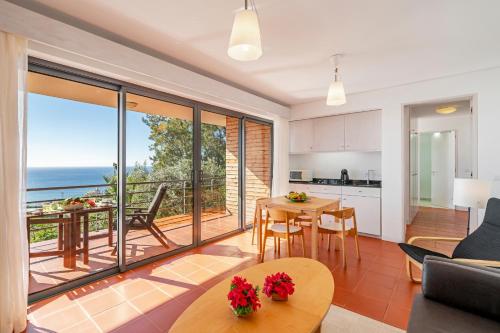 a kitchen and living room with a view of the ocean at Casa do Papagaio Verde in Funchal
