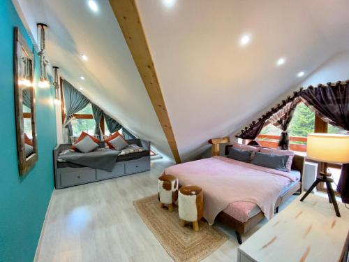 ブシュテニにあるKalinderu Ski Loftのベッドルーム1室(ベッド1台、ソファ付)