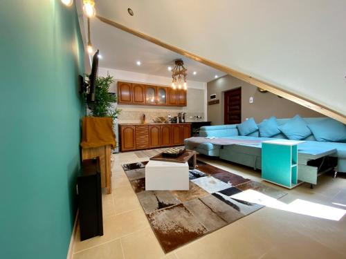 uma sala de estar com uma cama azul e uma cozinha em Kalinderu Ski Loft em Buşteni