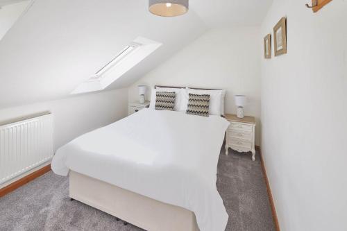 a white bedroom with a white bed and a window at Host & Stay - Robins Den in Whitby