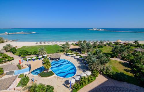 an aerial view of a resort with a pool and the ocean at Danat Jebel Dhanna Resort in Jebel Dhanna
