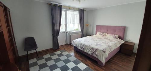 een slaapkamer met een roze bed en een raam bij D&Y Apartments in Piatra Neamţ