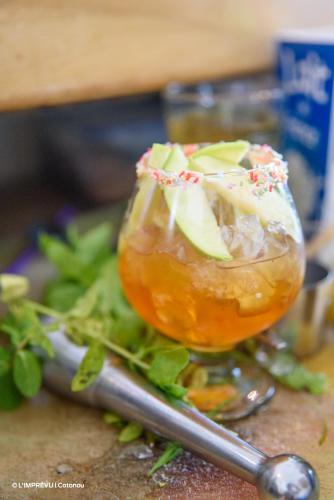a glass of iced tea with apples and a spoon at L'imprévu in Cotonou