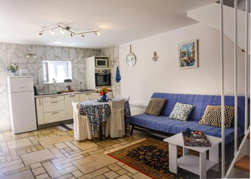 a living room with a blue couch and a kitchen at Vila Vinci 1906 in Vrsar