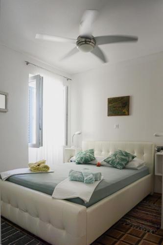 a bedroom with a large bed with a ceiling fan at Vila Vinci 1906 in Vrsar