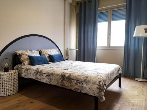 une chambre avec un grand lit avec des oreillers bleus dans l'établissement Appartement Carré d'Or Vue sur Mer, à Nice