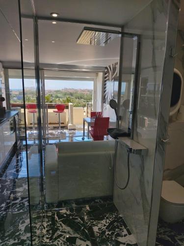- une cabine de douche en verre dans un salon dans l'établissement Naturiste Cap d'Agde Port Nature 482, au Cap d'Agde