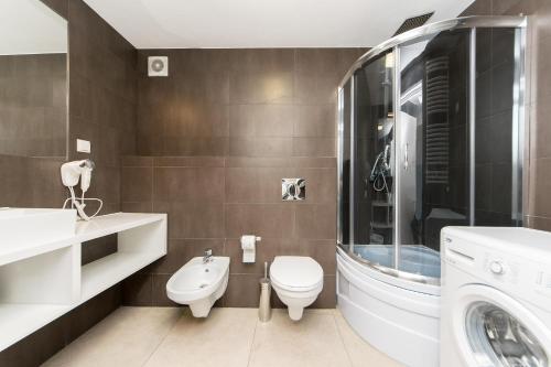 a bathroom with a toilet and a sink and a washing machine at Exclusive Loft in the Main Square A/C p4you pl in Krakow