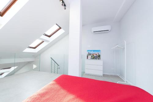 een witte slaapkamer met een rood tapijt op het bed bij Exclusive Loft in the Main Square A/C p4you pl in Krakau