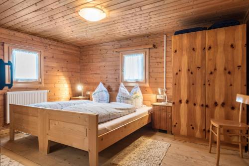 a bedroom with a bed in a wooden cabin at Ferienwohnung Krösshof in Sarntal