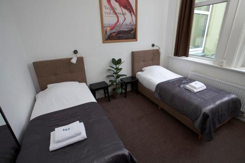 a bedroom with two beds and a window at Bed & Breakfast Hotel Malts in Haarlem