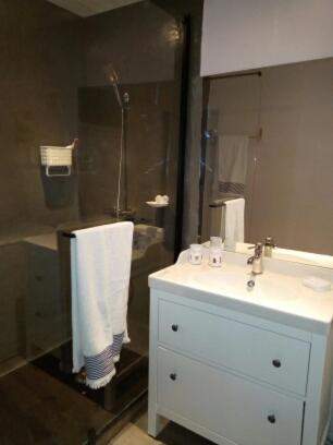 une salle de bain avec un lavabo blanc et une douche dans l'établissement fleur de lune, à Vals-les-Bains