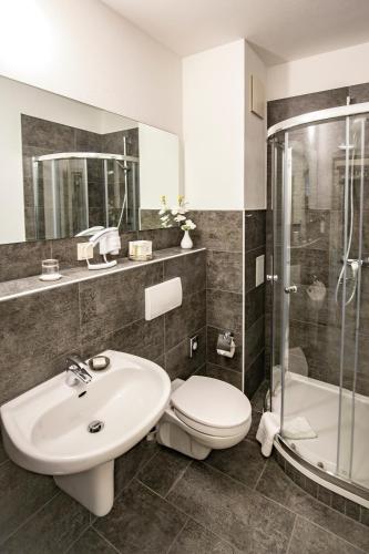 a bathroom with a sink and a toilet and a shower at Hotel "Zur Mühle" in Hoyerswerda