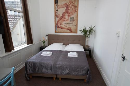 a bedroom with a bed with two towels on it at Bed & Breakfast Hotel Malts in Haarlem