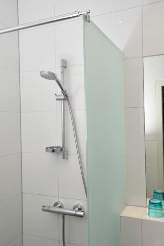 a shower in a bathroom with a glass door at Bed & Breakfast Hotel Malts in Haarlem