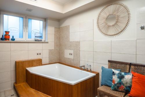 a bathroom with a bath tub and a mirror at Nowa - Ski SPA Hotel in Karpacz