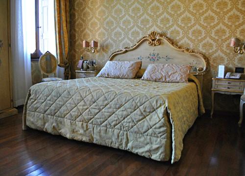a bedroom with a large bed with a gold frame at Hotel Carlton On The Grand Canal in Venice