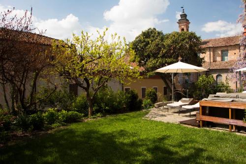 a garden with a table and chairs and an umbrella at L'Aromatario in Neive