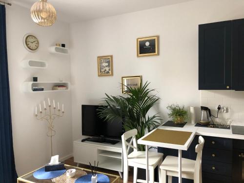 a kitchen and dining room with a table and a tv at Blue Dior Apartment Warsaw in Warsaw