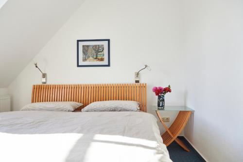 a bedroom with two beds and a table with flowers at Haffblick Rerik in Rerik