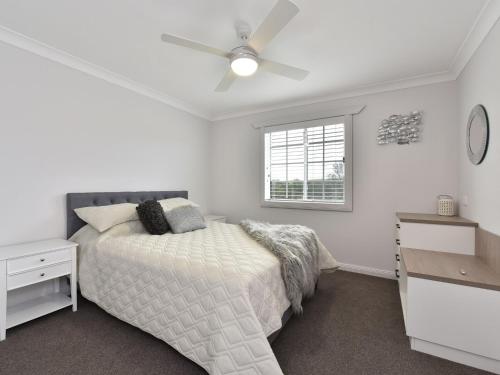 a bedroom with a bed and a ceiling fan at Malolo Park Guest House in Quorrobolong