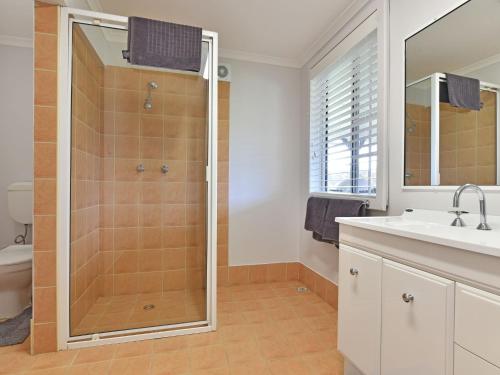 a bathroom with a shower and a sink at Malolo Park Guest House in Quorrobolong