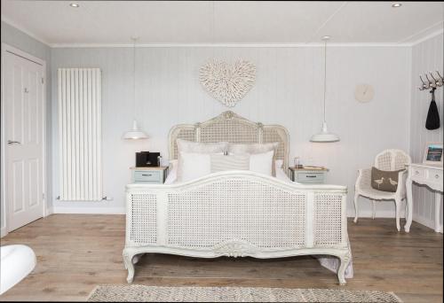 a white bedroom with a white bed and a desk at Sea View Snugs at Laggan in Gatehouse of Fleet